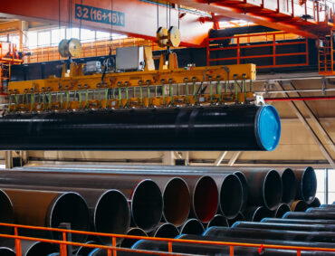 Coated pipe transportation by overhead crane with vacuum handling grippers.