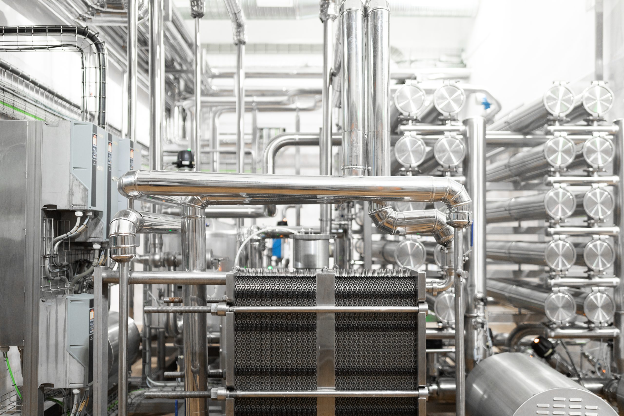 Modern brewery factory interior. pipe lines and other equipment tool in plant workshop. Industrial background. Metal pipes close-up. Industrial plant inside view. Maze of pipes background