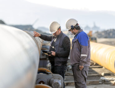 Non-destructive testing technicians are checking welds of pipe with ultrasonic testing (UT) method. Ultrasonic testing is often performed on steel and other metals and alloys.